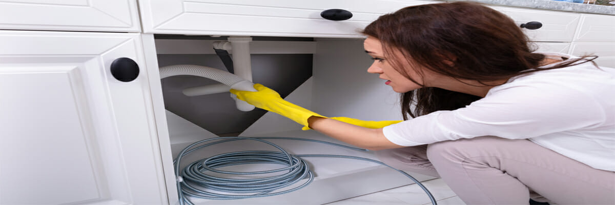 a woman cleans her smelly kitchen drain